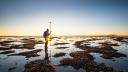 A person does measurements in the undeep waters of an estuary