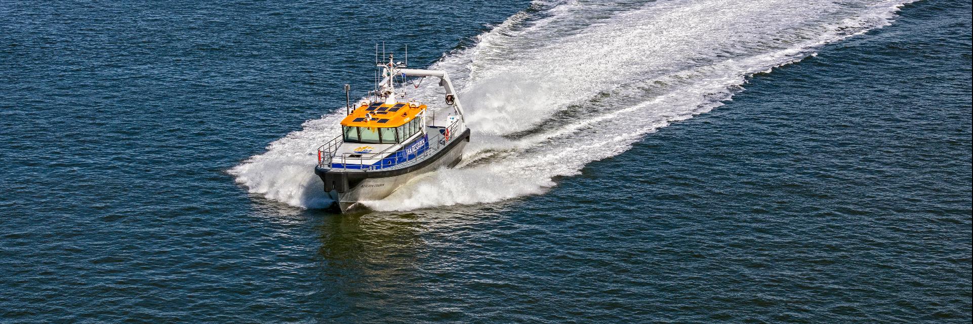 A drone shot from the research ship RV Adriaen Coenen, making a turn on a clear blue sea.
